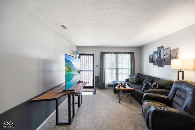 living room featuring a textured ceiling and carpet flooring