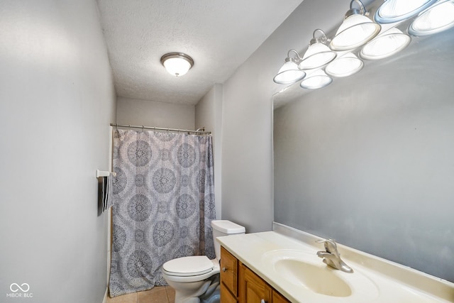 bathroom with vanity, toilet, tile patterned flooring, and a textured ceiling