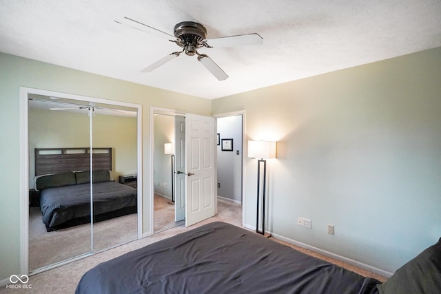 carpeted bedroom featuring ceiling fan and multiple closets