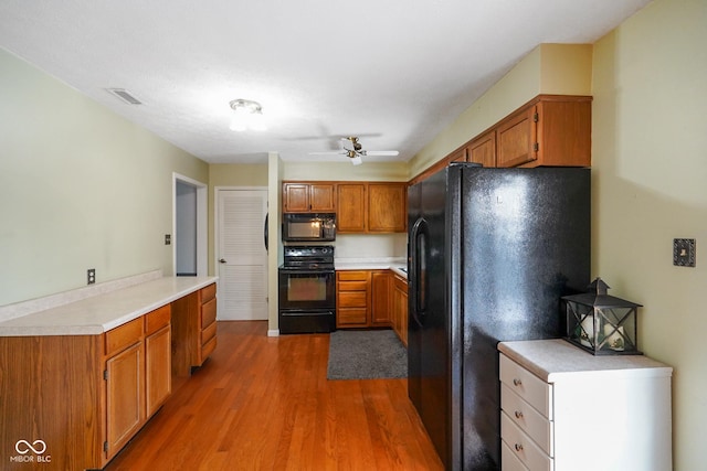 kitchen featuring wood-type flooring, ceiling fan, and black appliances