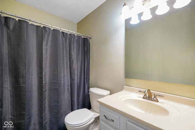 bathroom with vanity, a textured ceiling, and toilet