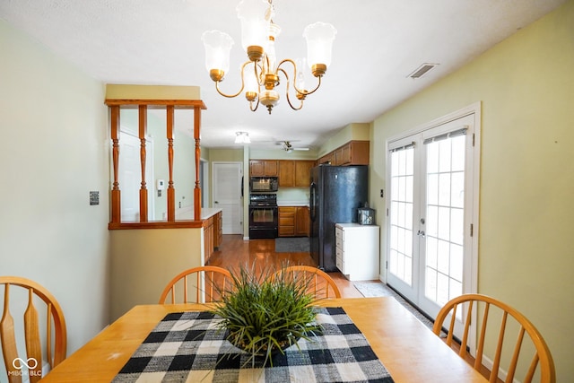 dining area featuring french doors, light hardwood / wood-style flooring, and a notable chandelier