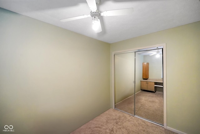 bedroom featuring ceiling fan, light colored carpet, and a closet