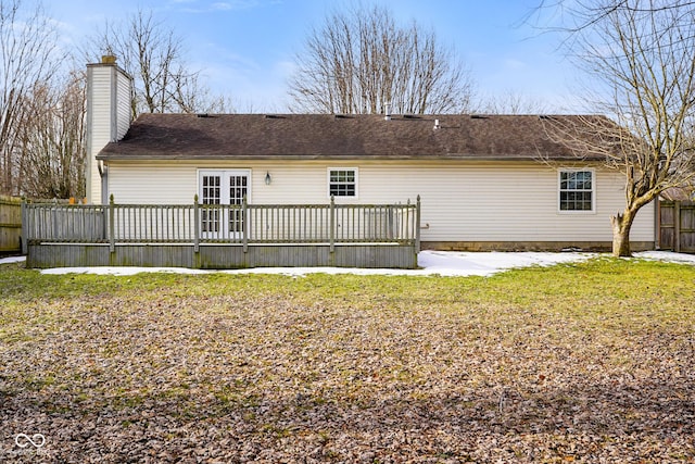 rear view of house featuring french doors, a deck, and a lawn