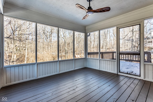 unfurnished sunroom featuring ceiling fan