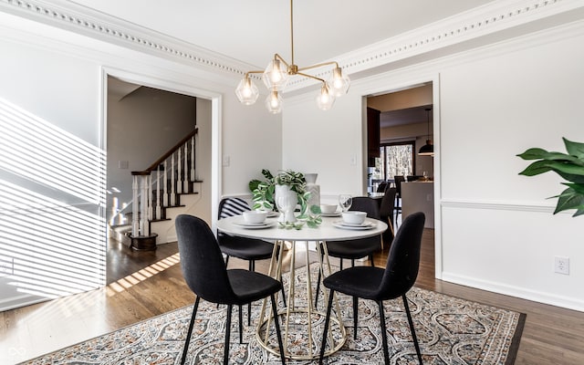 dining space featuring ornamental molding, dark hardwood / wood-style floors, and an inviting chandelier