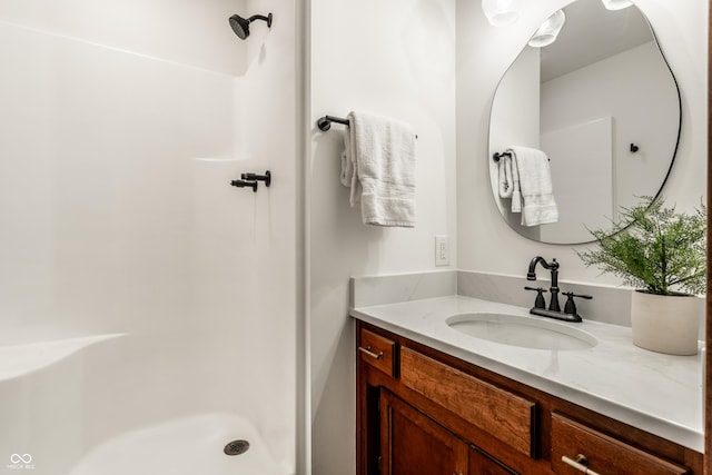 bathroom with walk in shower and vanity