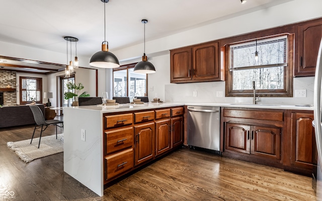 kitchen with pendant lighting, sink, stainless steel dishwasher, and kitchen peninsula