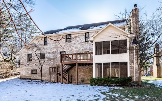 snow covered house featuring a sunroom, a deck, and ceiling fan