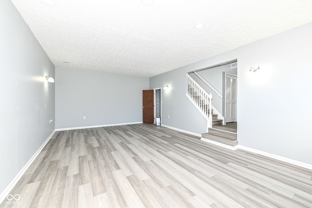 unfurnished room featuring light hardwood / wood-style flooring and a textured ceiling