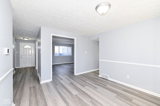 interior space featuring a textured ceiling and light wood-type flooring