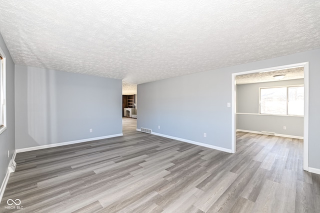 empty room featuring light hardwood / wood-style flooring and a textured ceiling