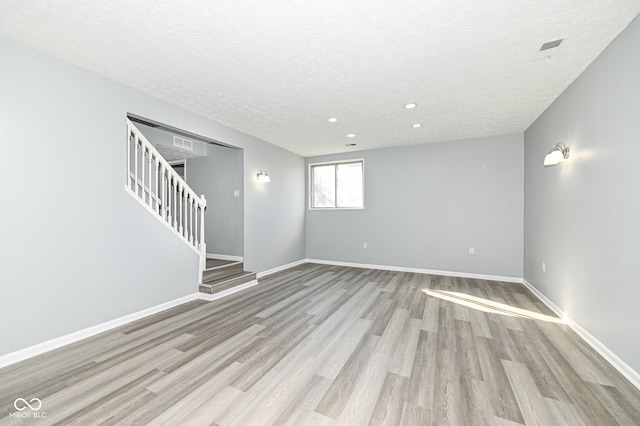 interior space featuring a textured ceiling and light wood-type flooring