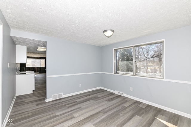 unfurnished room with dark hardwood / wood-style floors and a textured ceiling