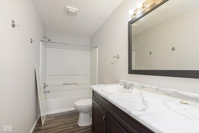 full bathroom with wood-type flooring, shower / bath combination, vanity, toilet, and a textured ceiling