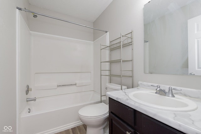 full bathroom featuring toilet, a textured ceiling, shower / tub combination, vanity, and hardwood / wood-style flooring