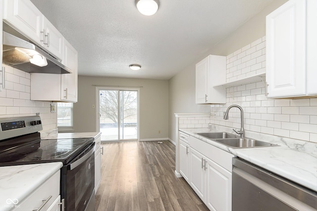 kitchen featuring sink, white cabinets, dark hardwood / wood-style flooring, stainless steel appliances, and light stone countertops