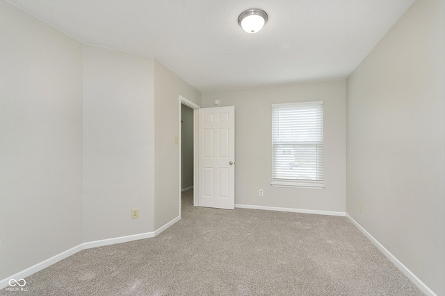 carpeted empty room featuring a textured ceiling