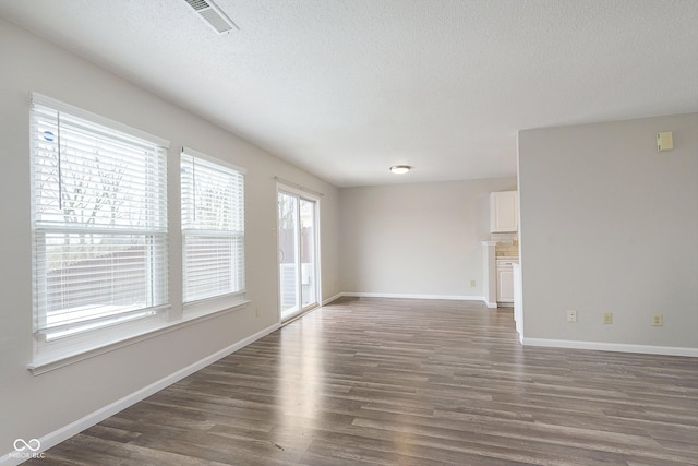 spare room with dark wood-type flooring and a textured ceiling