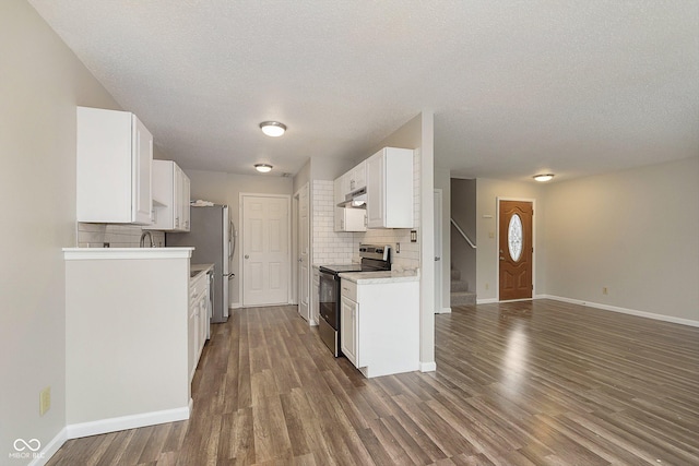 kitchen featuring white cabinetry, stainless steel appliances, dark wood-type flooring, and decorative backsplash