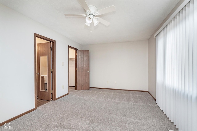 spare room featuring light carpet, a textured ceiling, and ceiling fan