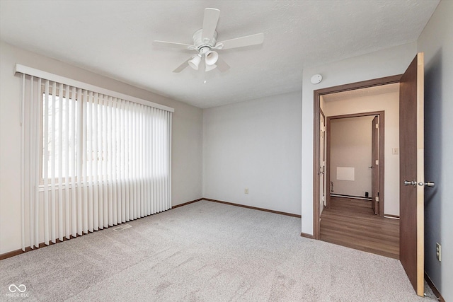 carpeted spare room with a textured ceiling and ceiling fan