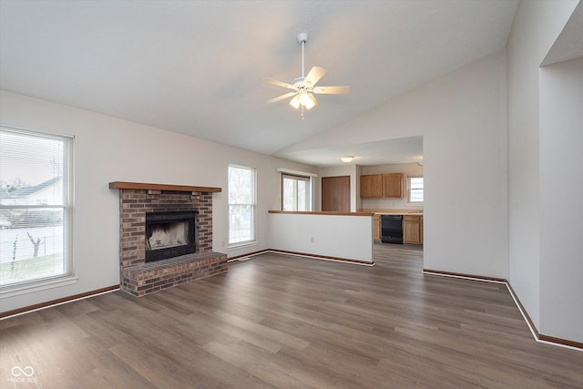 unfurnished living room with lofted ceiling, a fireplace, dark hardwood / wood-style floors, and ceiling fan