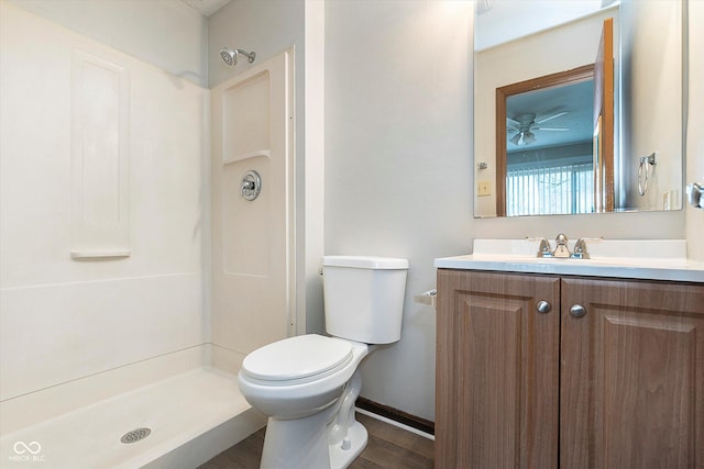 bathroom with hardwood / wood-style flooring, vanity, a shower, and toilet