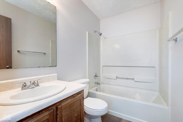 full bathroom with washtub / shower combination, vanity, toilet, and a textured ceiling