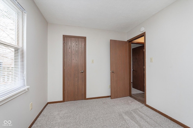 unfurnished bedroom featuring light colored carpet and a textured ceiling