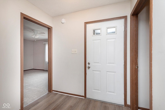 foyer with ceiling fan, a textured ceiling, and light hardwood / wood-style floors