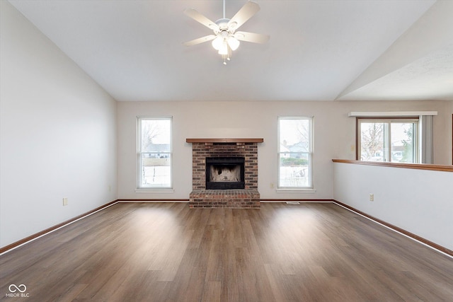 unfurnished living room featuring dark hardwood / wood-style flooring, a brick fireplace, vaulted ceiling, and ceiling fan