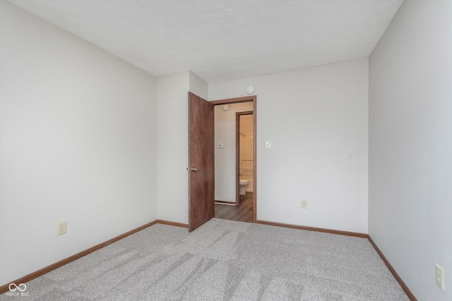 carpeted spare room with a textured ceiling