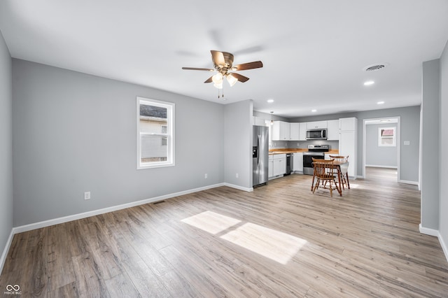 living room with light hardwood / wood-style floors and ceiling fan