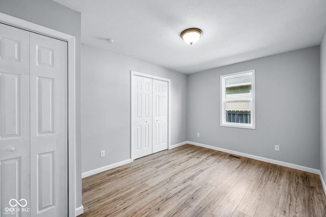 unfurnished bedroom with a closet and light hardwood / wood-style flooring