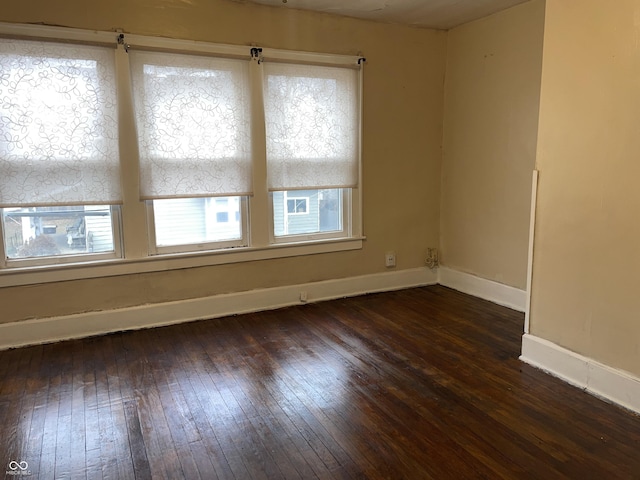 unfurnished room featuring dark hardwood / wood-style floors and a wealth of natural light