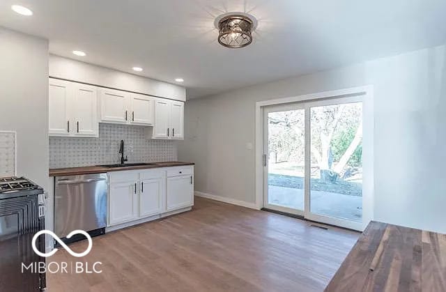 kitchen featuring tasteful backsplash, dishwasher, range, and white cabinets