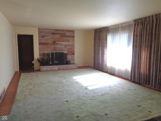 unfurnished living room featuring a stone fireplace