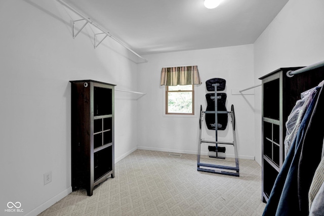 exercise room with baseboards and carpet flooring