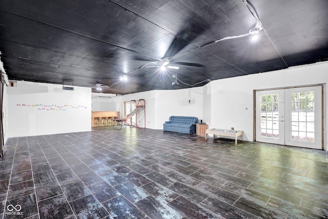 basement with french doors and a ceiling fan