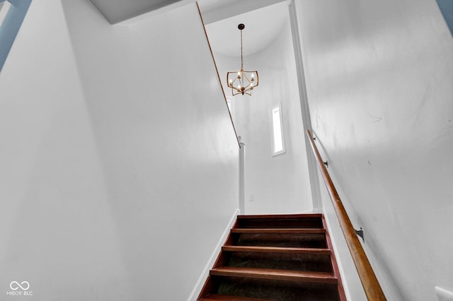 staircase with baseboards and a notable chandelier
