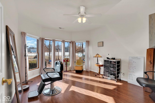 living area with plenty of natural light, a ceiling fan, wood finished floors, and visible vents