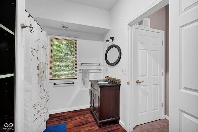 bathroom featuring baseboards, vanity, wood finished floors, and visible vents