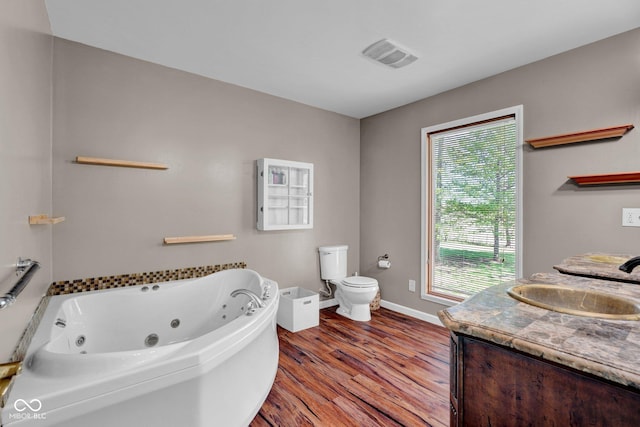 full bath featuring toilet, a jetted tub, baseboards, wood finished floors, and visible vents