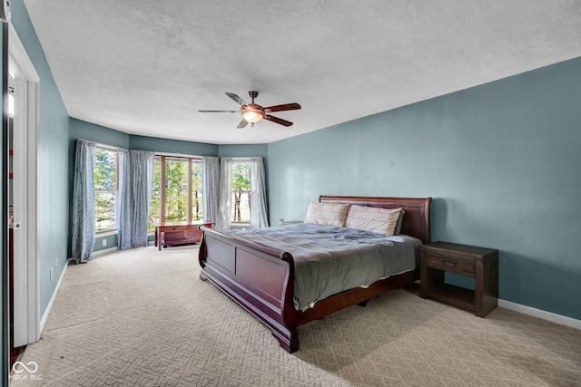 bedroom featuring baseboards, carpet, a textured ceiling, and a ceiling fan