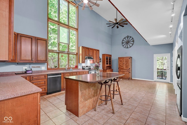 kitchen featuring ceiling fan, rail lighting, high vaulted ceiling, stainless steel appliances, and light tile patterned flooring