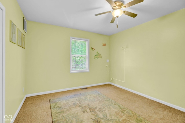 carpeted empty room featuring baseboards, ceiling fan, and visible vents