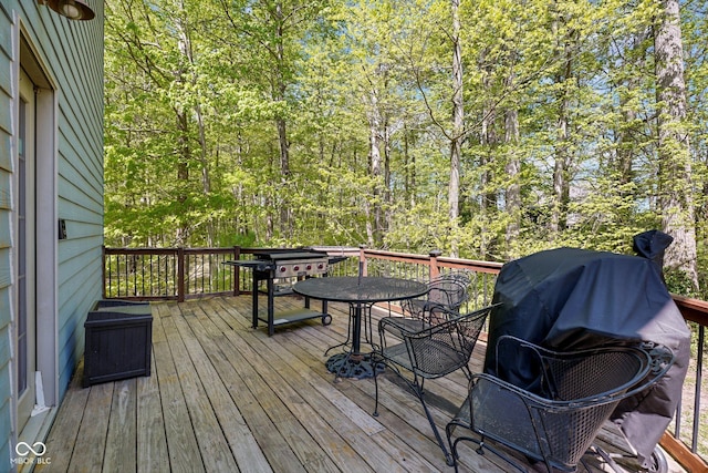 deck featuring outdoor dining space and area for grilling