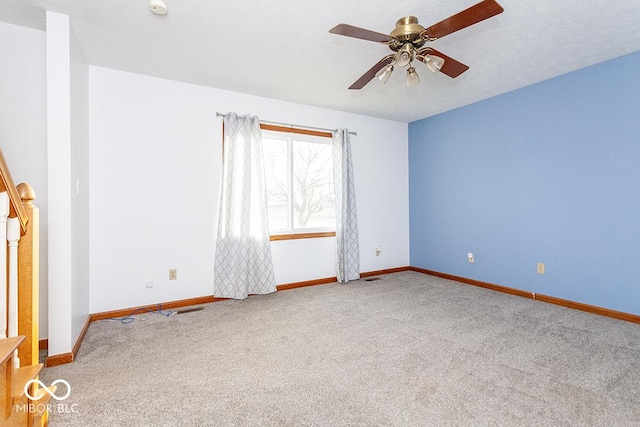 spare room featuring a textured ceiling, carpet flooring, and ceiling fan