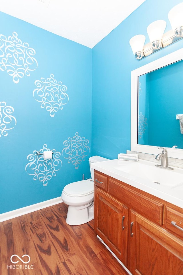 bathroom with hardwood / wood-style flooring, vanity, and toilet